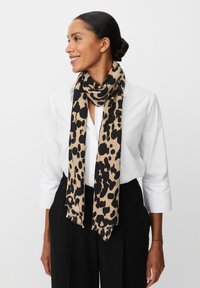 Sciarpa con stampa leopardata in beige e nero, realizzata in tessuto morbido, con bordi frangiati e un design leggero e fluido.