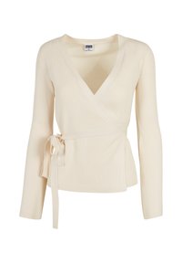Off-white ribbat topp med långa ärmar, V-ringning och ett knytbälte som accent vid midjan. Blandad bomullstyg.