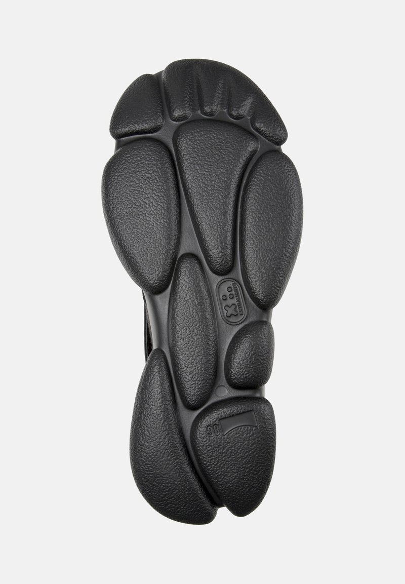 Suela de zapato de goma negra con elementos redondeados y superficie texturada. Incluye marcado de tamaño y logo en la parte inferior.