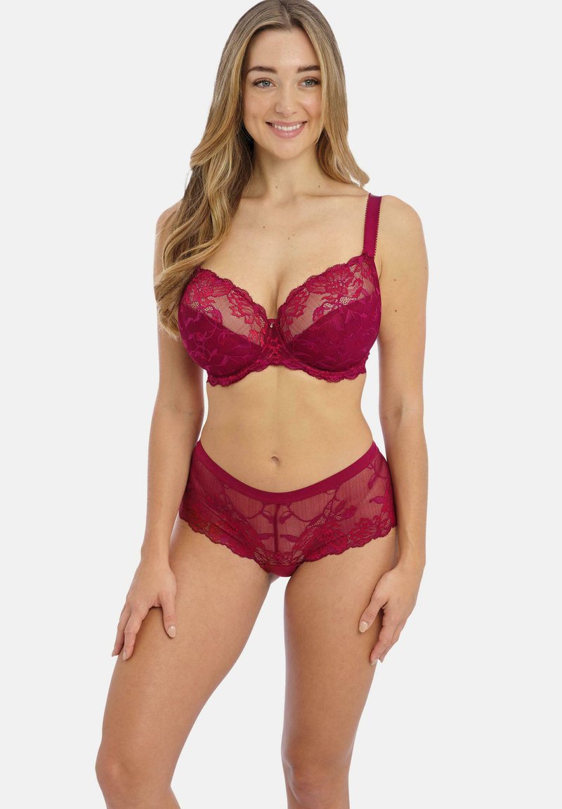 Conjunto de sujetador y braguitas de encaje burdeos con patrones florales, un diseño delicado y tirantes ajustables, que exhibe texturas transparentes y opacas.