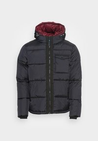 Námořnická péřová bunda s vínově červenou podšívkou, s vodorovným prošitím, předním zipem a náprsní kapsou. Černé detaily na zipu a manžetách.