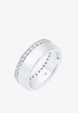 Anillo de plata con una banda lisa y pulida, adornado con una fila de piedras preciosas transparentes en el borde superior. Marcado con "925" en su interior.