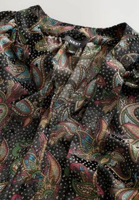 Voogav must blouse lively paisley mustriga, millel on kerge, läbipaistev tekstuur ja peened täpid kogu pinnal.