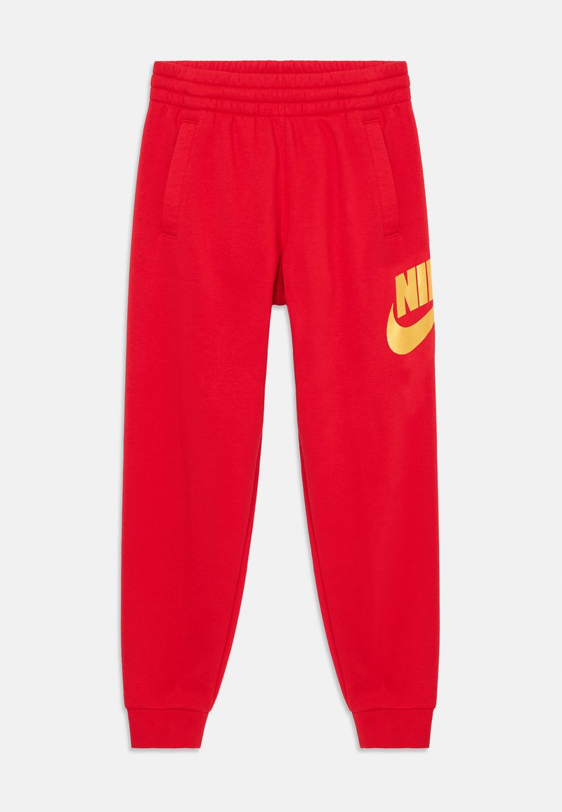Červené tepláky vyrobené z mäkkého materiálu, s elastickým pásom, dvoma bočnými vreckami a veľkým žltým logom Nike na ľavom stehne.