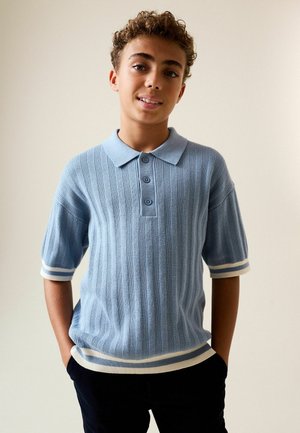 Lyseblå ribbet kortærmet polo-shirt med krave, der har tre knapper og hvide stribede detaljer på ærmer og kant.