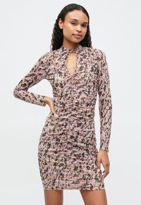 Prozoren, nabran obleka v roza barvi z živalskim vzorcem. Ima dolge rokave in dekolte s ključavnico ter zavezo. Gladka tekstura in prilegajoča oblika.