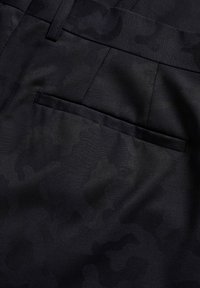 Pantaloni neri con un sottile motivo mimetico tono su tono, realizzati in un tessuto texturizzato con una parte anteriore piatta e un dettaglio della tasca posteriore.