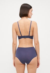 Soutien-gorge bleu marine avec des bretelles ajustables et une fermeture à agrafes, accompagné d'une culotte taille haute assortie. Tissu lisse et extensible.