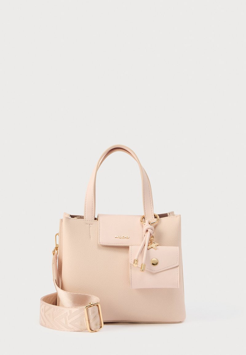 Sac à main rose clair en matériau texturé avec des anses courtes, une bandoulière détachable et une petite poche attachée. Accents de quincaillerie en or inclus.