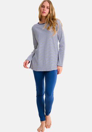 Haut rayé à manches longues en blanc et bleu marine avec des fentes sur les côtés, associé à un legging bleu moulant. Tissu doux avec une texture lisse.