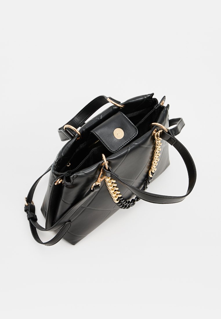 Sac à main noir matelassé en matériau synthétique, avec quincaillerie dorée et deux poignées : une courte et une longue avec des accents en chaîne.