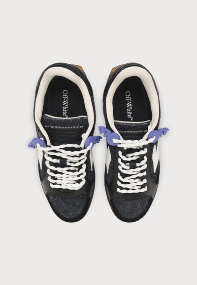 Paire de baskets Off-White noires et blanches avec lacets blancs et bloque-lacets violets, vues de dessus sur un fond blanc uni.