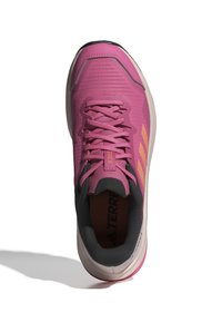 Zapatilla deportiva rosa con parte superior de malla, detalles en gris y tres franjas naranjas. Punta redonda, superficie texturizada y suela acolchada.