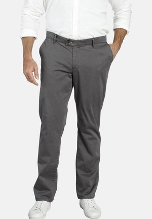 Graue Hose aus einem Baumwollmix, mit geradem Bein, zwei Taschen und einem Knopfverschluss. Kombiniert mit weißen Turnschuhen.