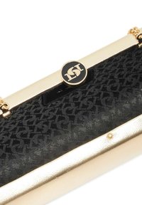Black fabric clutch bag with embossed pattern, gold metallic accents, and a circular logo clasp; smooth texture and rectangular shape.