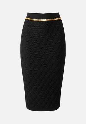 Gonna a matita nera fino al ginocchio con motivo geometrico testurizzato e sottile cintura a catena d'oro in vita su sfondo bianco.