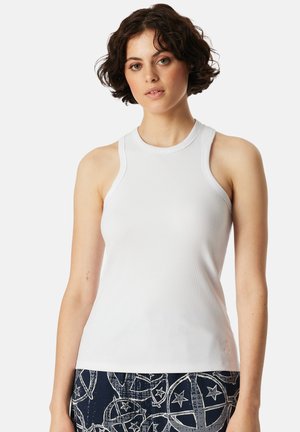 Witte mouwloze tanktop met een geribbelde textuur, ronde hals en schouderuitsparingen, gecombineerd met een patroon van marineblauwe onderkant met sterren.