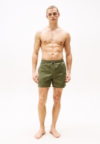 Pantaloni scurți de înot pentru bărbați, de culoare verde măsliniu, cu talie elastică și șnur pentru strângere. Materialul pare ușor, cu o textură fină și fără motive vizibile.