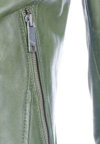 Grön läderjacka med en metallisk dragkedja, texturerad yta och synlig söm längs sidleden för extra detalj.