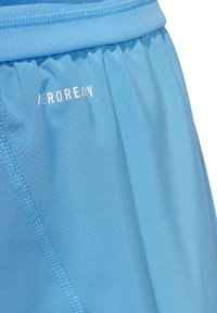Pantaloni sportivi azzurri chiari realizzati in tessuto liscio, dotati di una cintura elastica e di un logo stampato, con cuciture piatte per una maggiore durabilità.