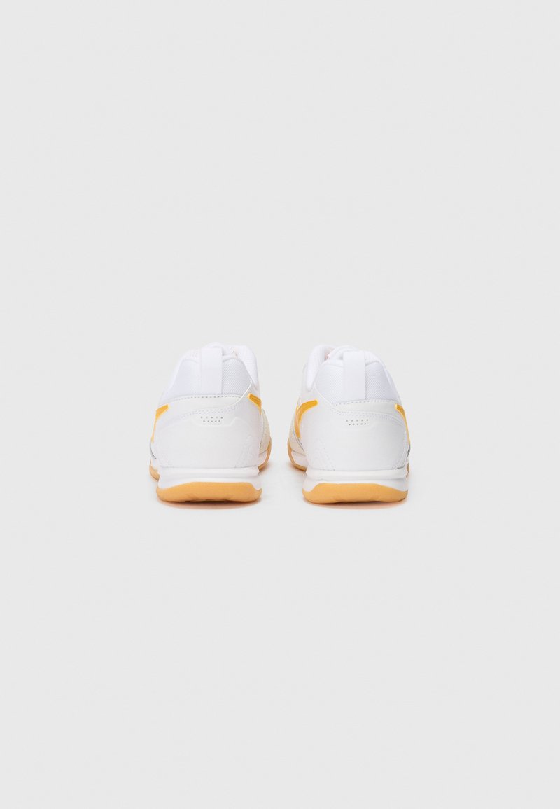 Zapatillas deportivas blancas con un upper texturizado, que presentan detalles en amarillo y una suela de goma. Diseño sencillo con un acabado suave y pestañas en el talón.