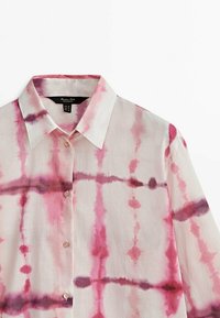 Short-sleeve, button-up shirt in lightweight fabric, featuring a pink and white tie-dye pattern with subtle purple accents and a pointed collar.