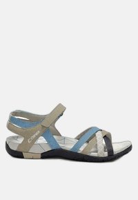 Un sandalo beige e blu con cinturini incrociati, una soletta imbottita, dettagli testurizzati e una suola in gomma nera con motivi.