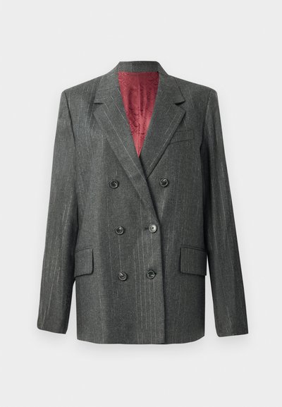 Blazer doppiopetto in tessuto grigio scuro con sottili righe, dotato di bottoni neri, revers a punta e una fodera rossa a contrasto.