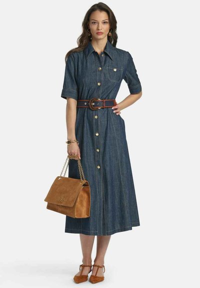 Rövid ujjú farmerruha, elöl gombokkal, övvel a deréknál és bővülő szoknyával. Barna velúr kézitáska és hozzá illő cipők.