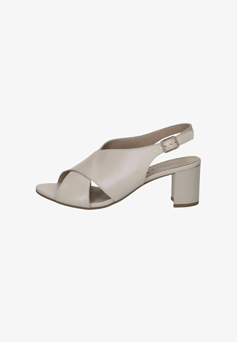 Sandale beige à bride arrière avec un design croisé, bout ouvert et talon épais. Fabriquée en matériau synthétique lisse avec une bride texturée.