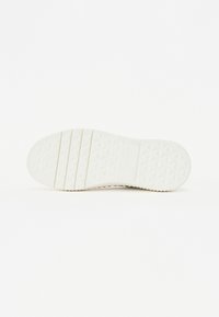 White rubber shoe sole featuring a textured, diamond-pattern grip and segmented design, with a logo imprint on the heel section.