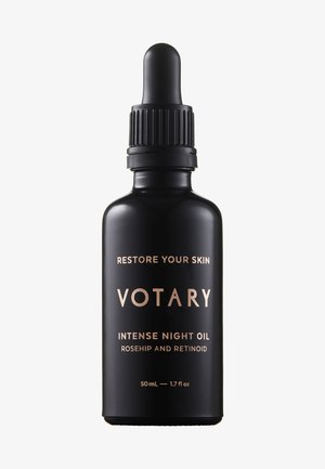 Sort glaskande med en pipette, der prydes af guldtekst, der siger "VOTARY INTENSE NIGHT OIL," fremhævende ingredienser som hybenolie og retinoid.