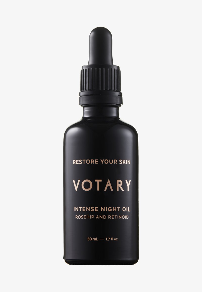 Svart glasflaska med pipett, med guldtext som lyder "VOTARY INTENSE NIGHT OIL," som framhäver ingredienser av nypon och retinoid.