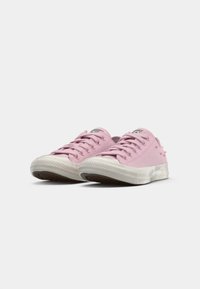 Rosa kanvas sneakers med hvite gummisåler, rund tå og flate snører. Har sideakenter og en klassisk logo på tungen.