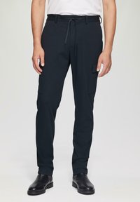 Zwarte cargobroek met een koord in de taille, zijzakken en taps toelopende pijpen, gemaakt van een duurzame stof met een gladde afwerking.