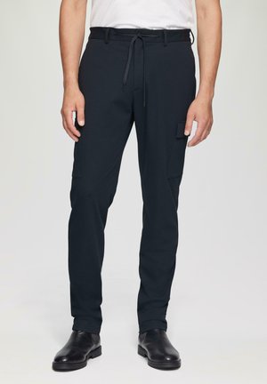 Zwarte cargobroek met een koord in de taille, zijzakken en taps toelopende pijpen, gemaakt van een duurzame stof met een gladde afwerking.