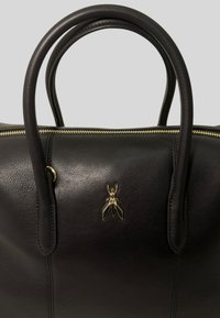 Borsa a tracolla in pelle nera con manici arrotondati doppi, hardware dorato e un emblema decorativo di insetto sulla parte anteriore. Chiusura a zip lungo la parte superiore.