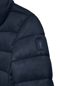 Giacca puffer blu navy con texture trapuntata sulle spalle. Presenta un patch rettangolare con la silhouette di un golfista sul braccio sinistro.