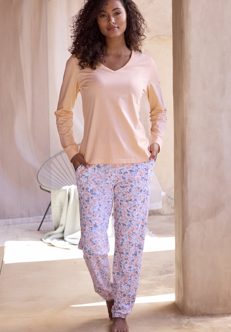 Peach long-sleeve v-neck top paired with light-patterned pajama pants, featuring pink, blue, and gray floral designs. Soft fabric, relaxed fit.