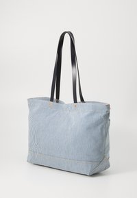 Striped fabric tote bag with navy handles, rectangular shape, open top, and orange accents. Lightweight and spacious for daily use.