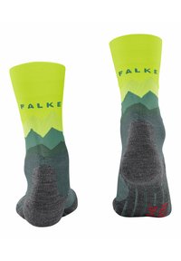 Calcetines verdes y amarillos con un patrón de montañas; parte superior acanalada, puntera y talón reforzados, logo de FALKE en el cañón en azul. Tejido suave y texturizado.
