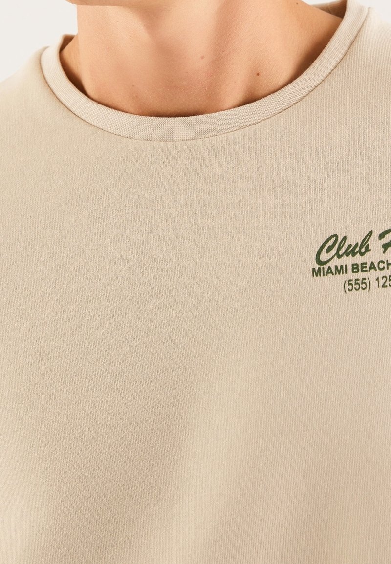 Sweat-shirt NCO en Beige | ABOUT YOU