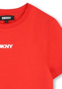 Rode katoenen T-shirt met een ronde hals, voorzien van een witte 'DKNY' logo op de voorkant. Gladde textuur en korte mouwen.