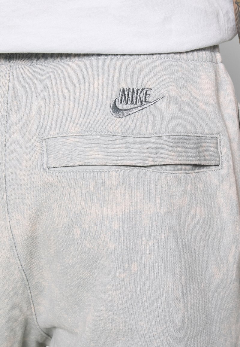 Ljusblå Nike sweatshirtbyxor med en texturerad yta. Har en bakficka och en broderad Nike-logga i grått på midjebandet.