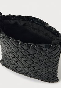 Czarna pleciona torba skórzana o teksturowanej powierzchni i materiałowej podszewce. Wyposażona w zaciąganą sznurkiem klapę oraz kompaktowy, prostokątny kształt.