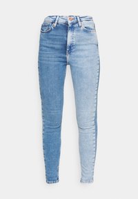 Smala jeans med en delad design i två nyanser av blå denim. Vänsterbenet är mörkt, högerbenet är ljust, med en traditionell femficksstil.