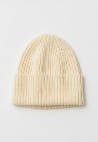 Berretto beige lavorato a maglia con una texture a coste, dotato di un risvolto piegato e una forma rastremata nella parte superiore. Materiale morbido, senza motivi visibili.