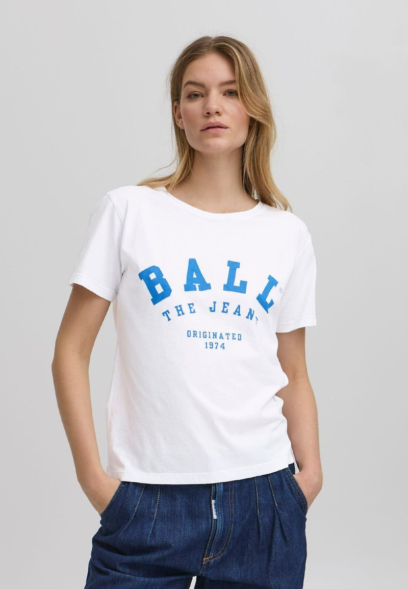 Hvit bomull T-skjorte med blå grafisk tekst "BALL THE JEAN" og "ORIGINATED 1974." Rund hals, korte ermer, avslappet passform, uformell stil.