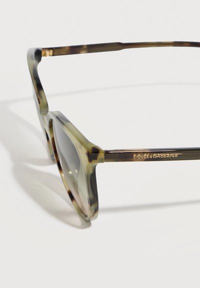 Ορθογώνια γυαλιά ηλίου με μοτίβο χελώνας, σκοτεινούς φακούς και λεπτά μπράτσα, με το λογότυπο "Dolce & Gabbana" στο πλάι.