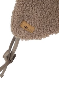 Textured beige wool headband with a stitched leather tag and a tied fabric strap for adjustment. Soft, fluffy surface with rounded edges.